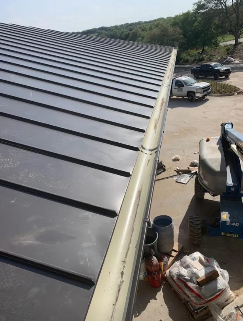 Standing seam panel and gutter detail on a metal roofing jobsite in Taylor